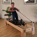 Align-Pilates M8-Pro RC Maple Wood Studio Reformer with model in studio diagonal view