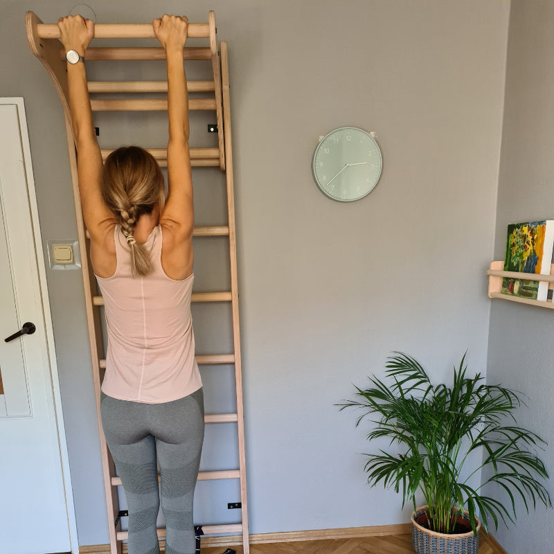 BenchK Wood Swedish Ladder with Pull Up Bar with Model hanging from bar