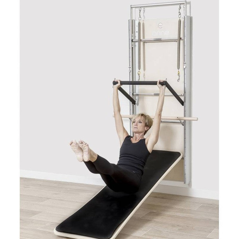 Elina Pilates Wall Board ONNE by eva espuelas fully equipped with ballet bar and mat table diagonal view legs extended